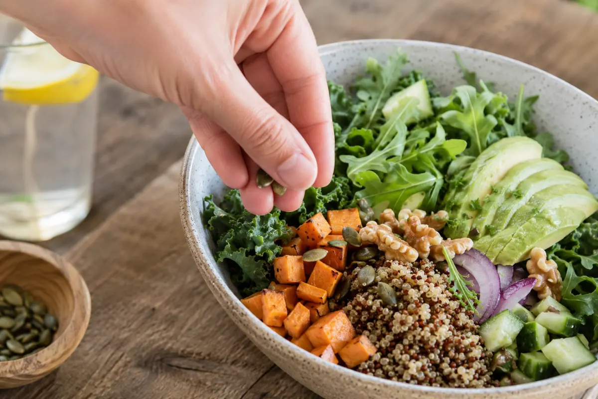 Mon menu alimentation anti-inflammatoire pour toute la semaine Gros plan sur une assiette de saumon avec épinards frais, graines de courge et quartiers de citron posée sur une table en bois