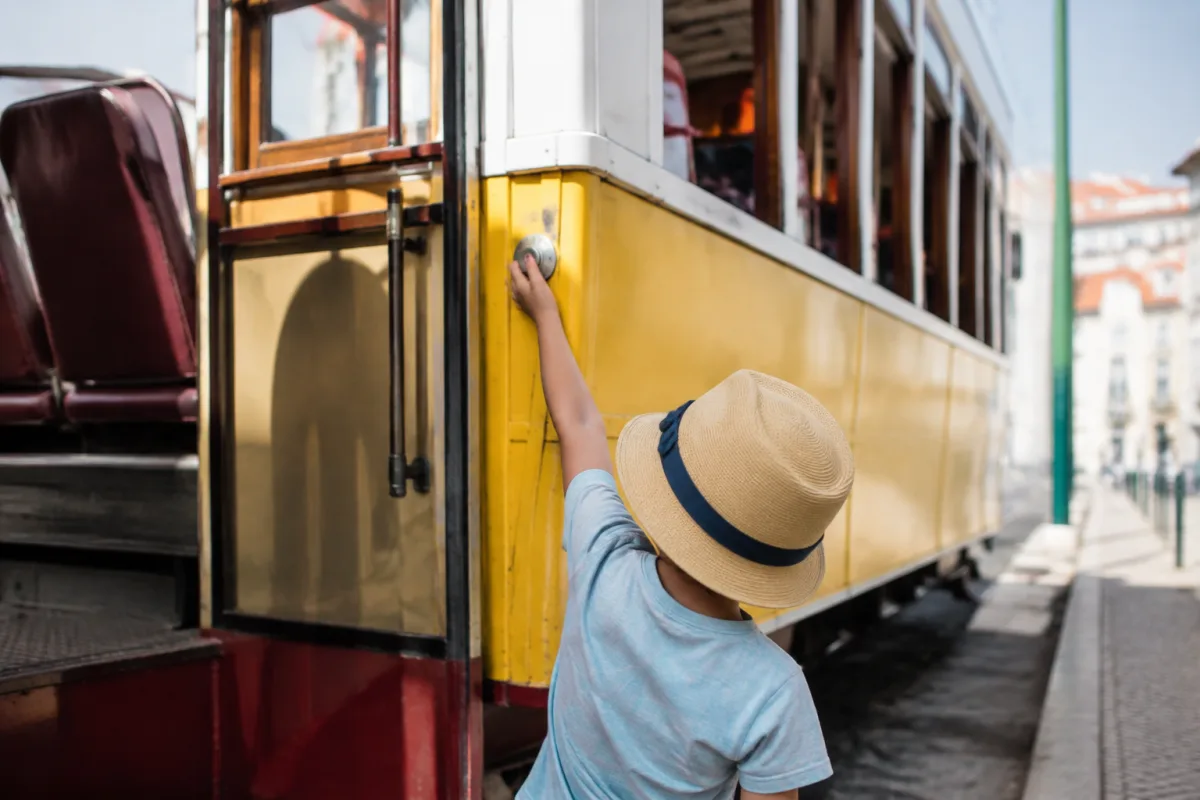 Enfant souriant tenant un pastel de nata devant la boulangerie de Bel&eacute;m &agrave; Lisbonne